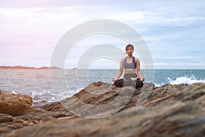 The woman practicing yoga sunset on the beach.