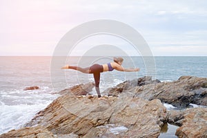 The woman practicing yoga sunset on the beach.