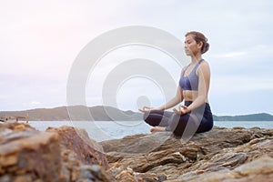 The woman practicing yoga sunset on the beach.