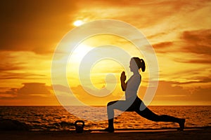 woman practicing yoga during surrealistic sunset at the seaside.