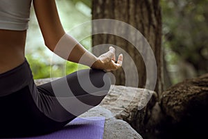 Woman practicing yoga in tropic environment