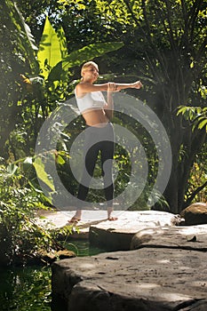 woman practicing yoga in tropic environment