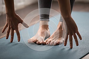 Woman practicing yoga, uttanasana pose, Head to knees close up