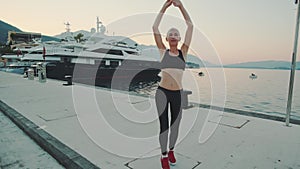 Woman practising sport exercises outdoor on the quay