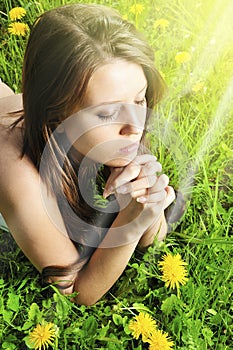 Woman prayer on green grass