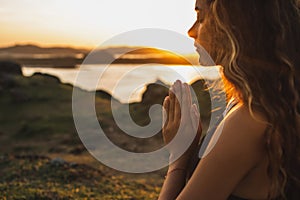 Woman praying alone at sunrise. Spiritual and emotional concept