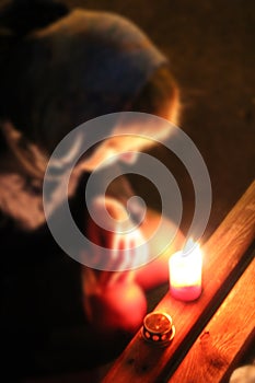 Woman praying with candle. Prayer in church with burning candle. Easter eve