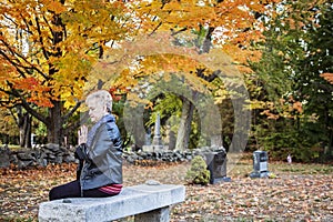 Woman praying in cemetery