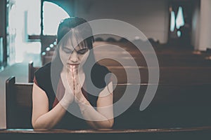 Woman praying in the church. Hands folded in prayer concept for faith, spirituality and religion