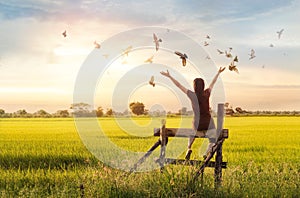 Woman praying and free bird enjoying nature on sunset background photo