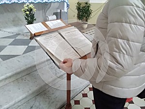 Woman praying on the Holy Bible. Holding hands in prayer on a wooden table