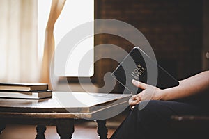 Woman praying on holy bible in the morning