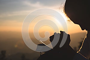 Woman praying in the morning on the sunrise background. Christianity concept. Pray background. Faith hope love concept photo