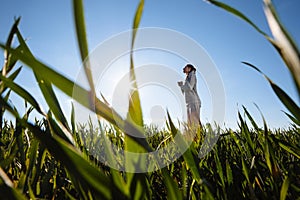 Woman praying outside on the green meadow