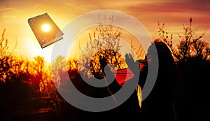 Woman praying pious with sunrise photo