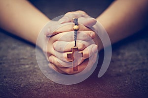 Woman praying with a rosary photo