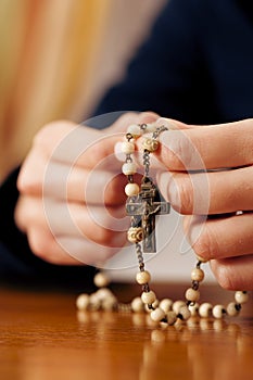 Woman praying with rosary to God