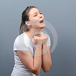 Woman praying about something or begging for mercy against gray background photo