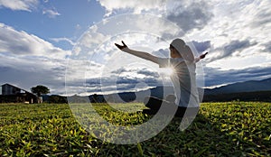 Woman praying for thank god praying with her hands together to think of a loving God, we praise God with light flare in the green