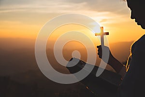 A women is praying to God on the mountain. Praying hands with faith in religion and belief in God on blessing background. Power of