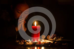 Woman Praying and worship to GOD Using hands to pray in religious beliefs and worship christian with Red Candle with fire against