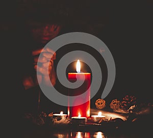 Woman Praying and worship to GOD Using hands to pray in religious beliefs and worship christian with Red Candle with fire against