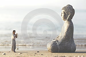 Woman prays meditating in front of the Buddha statue photo