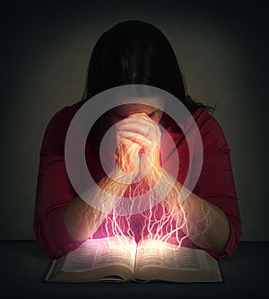 Woman prays over a Bible