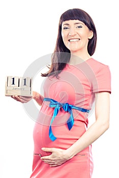 Woman in pregnant showing date of birth on cube calendar, expecting for newborn concept