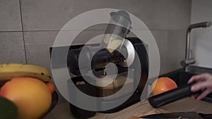 Woman prepare apple or pear juice in the morning using juicer at kitchen