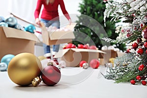 Woman prepare christmas tree with cardboard boxes full of christmas balls and decorations, preparation concept background with