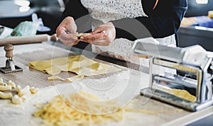 Woman prepare fresh ravioli inside pasta factory - Focus on hands