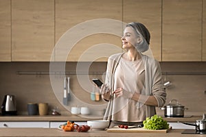 Woman prepare salad browse dish recipe using smartphone photo