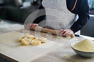 Woman prepare traditional pasta inside italian factory