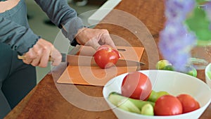 A woman prepares a bowl of tomatoes, a natural food ingredient, on a table