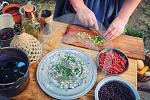 A woman prepares food for the first American prospectors gold. Women`s hands cut vegetables on a wooden Board in the United State photo