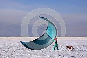 Woman prepares her kite. Snow kiting.
