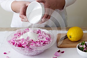 A woman prepares jam from roses, ingredients for jam from roses. Rustic style.