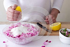 A woman prepares jam from roses, ingredients for jam from roses. Rustic style.