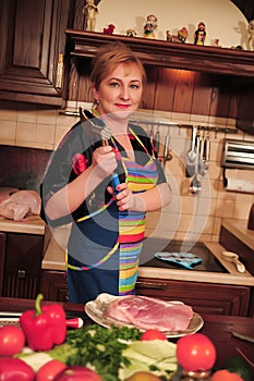 Woman prepares the meat in the kitchen