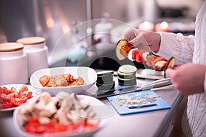 Woman prepares meat and vegetable skewers