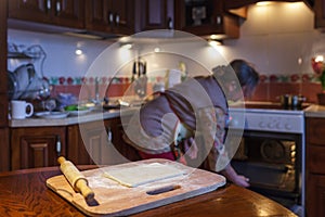 A woman prepares pies, warms up the oven.