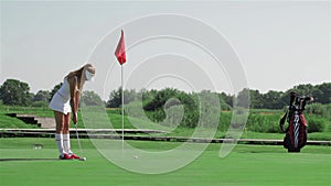 Woman prepares for the putting at the golf