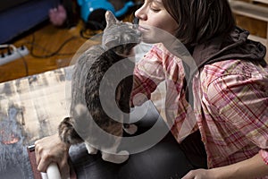 Woman prepares the surface for painting and sanding by hands an old wooden black table with a manual carpentry sandpapers holder,