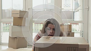 Woman prepares to unpack box in new house