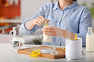 Woman preparing baby formula at table