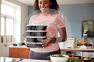 Woman Preparing Batch Of Healthy Meals At Home In Kitchen