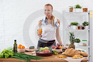 Woman preparing dinner in a kitchen, drinking juice concept cooking, culinary, healthy lifestyle.