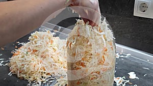 Woman preparing fresh vegetables for fermentation on table. Woman puts sauerkraut in a jar. HD video footage 1920x1080
