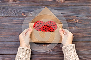 Woman preparing handmade envelope for wrapping on Valentine`s Day. Valentine day concept with copyspace